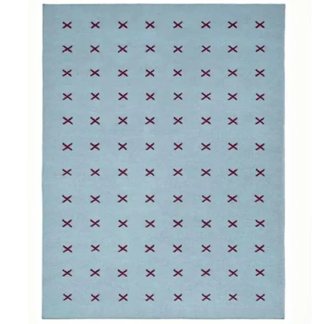 Scandinavian handwoven flatweave wool rug with a minimalist burgundy cross geometric pattern on a light blue background, handmade Nordic area rug for modern living room and bedroom.