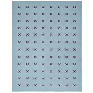 Scandinavian handwoven flatweave wool rug with a minimalist burgundy cross geometric pattern on a light blue background, handmade Nordic area rug for modern living room and bedroom.