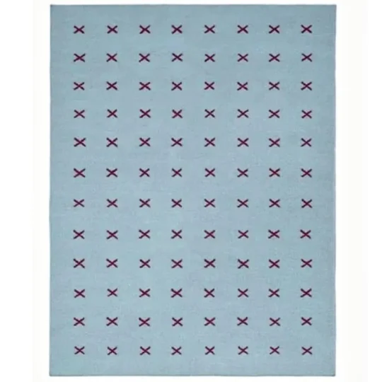 Scandinavian handwoven flatweave wool rug with a minimalist burgundy cross geometric pattern on a light blue background, handmade Nordic area rug for modern living room and bedroom.