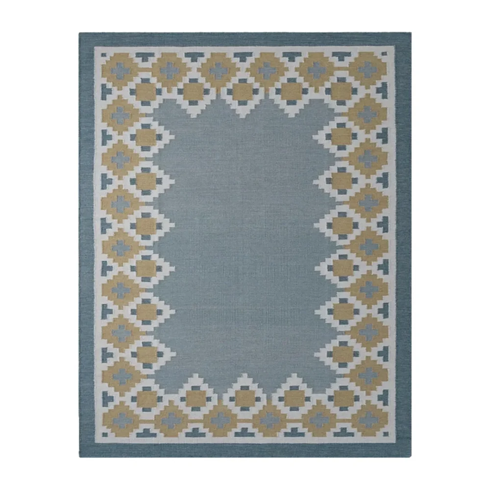 Nordis handwoven flatweave wool rug featuring a Scandinavian geometric border in blue, mustard, beige, and ivory, handmade for modern living rooms, bedrooms, and Nordic interiors.