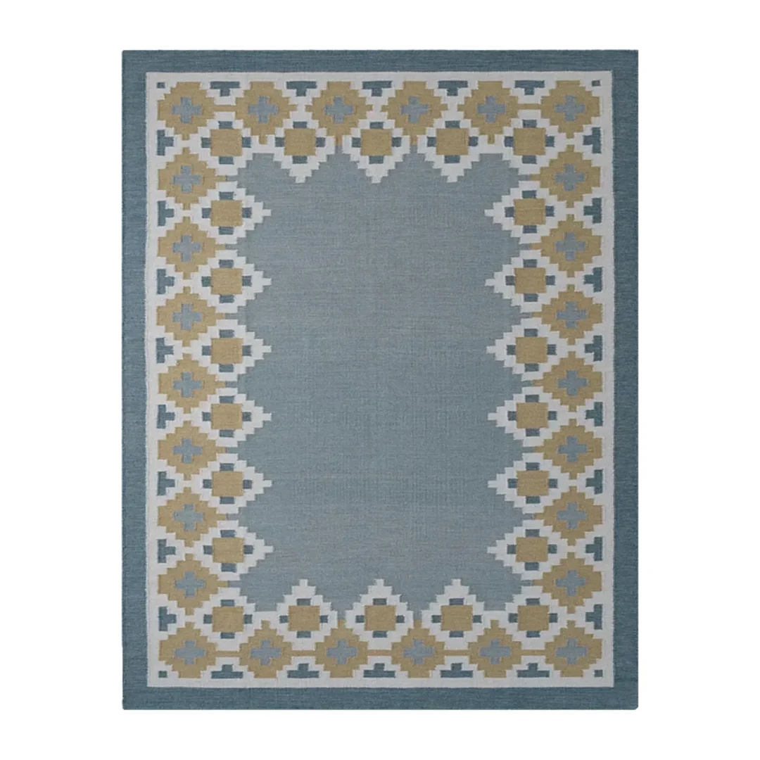 Nordis handwoven flatweave wool rug featuring a Scandinavian geometric border in blue, mustard, beige, and ivory, handmade for modern living rooms, bedrooms, and Nordic interiors.